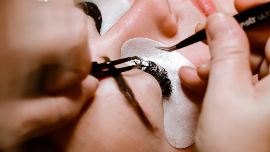 woman getting eyelash extensions service